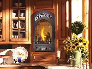 Stove insert with fire burning and cabinets with kitchenware. Sunflowers in a vase to the right