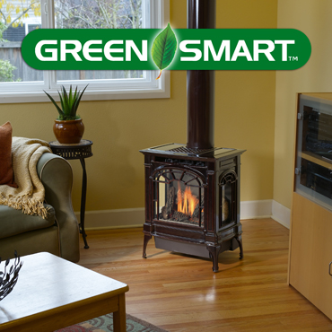 dark colored wood stove in room with table and couch near it. The word Green Smart spelled out up above.