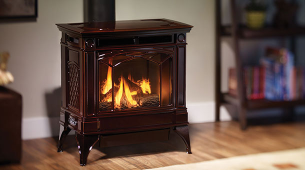 Wood Stove that is reddish in color with fire burning in it. A bookshelf in top right corner but blurred
