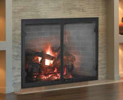 fireplace with glass doors and fire burning in it