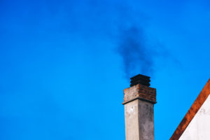 smoking chimney against blue sky