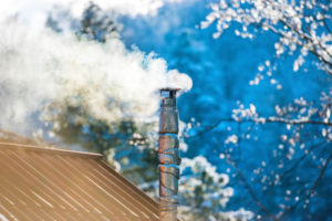 chimney with smoke against blue sky